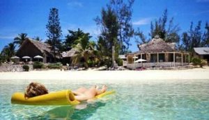 A woman relaxing on a yellow float in the water during her vacation in the Bahamas.