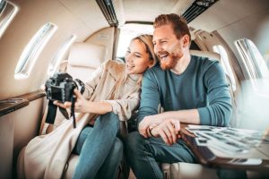 Charter flights to the Bahamas and in Florida A man and woman smile as they review photos on a camera's screen inside a private jet, reveling in the luxury of charter flights from Florida to the Bahamas. Charter a plane to the Bahamas or in Florida