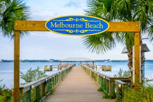 A wooden boardwalk extending to Melbourne Beach alongside charter flights in Florida.